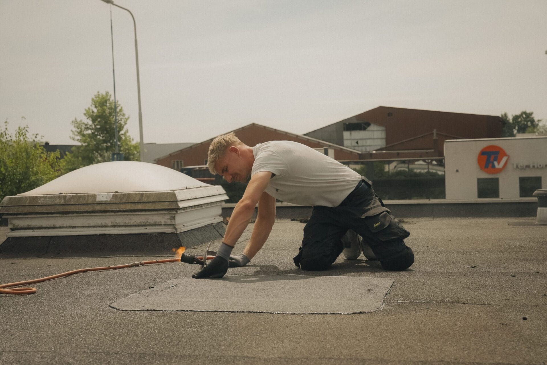 Roofiva dakdekker aan het werk op een plat dak