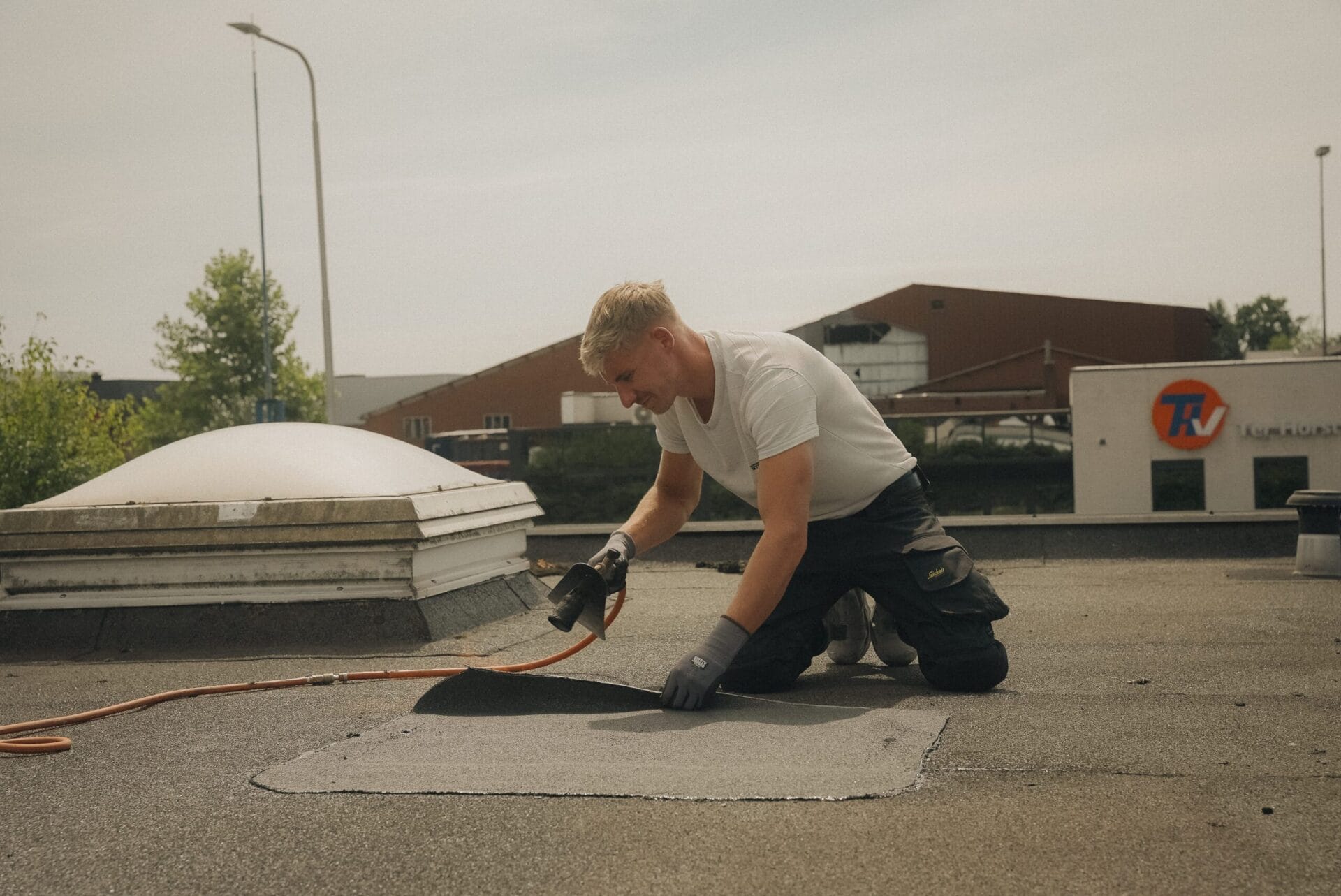 Roofiva dakdekker aan het werk op een plat dak